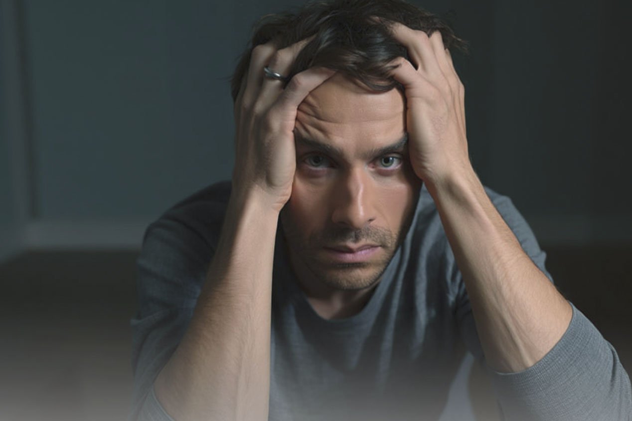 Мужчина держится руками за голову